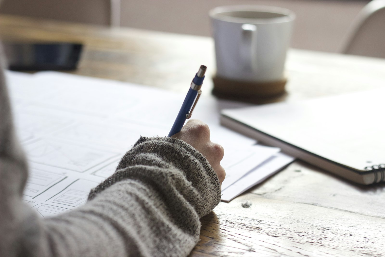 Brugklasser maakt huiswerk aan bureau met agenda en schrift